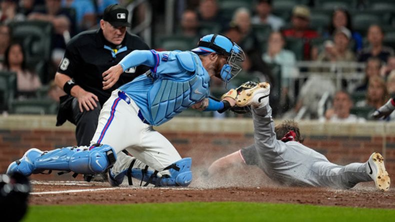 Daniel Schneemann (10), de los Guardianes de Cleveland, llega quieto al plato ante el receptor Jonah Heim (20), de los Bravos de Atlanta, durante una entrada de un juego de béisbol, el sábado 11 de abril de 2026, en Atlanta. (Foto AP/Mike Stewart)
