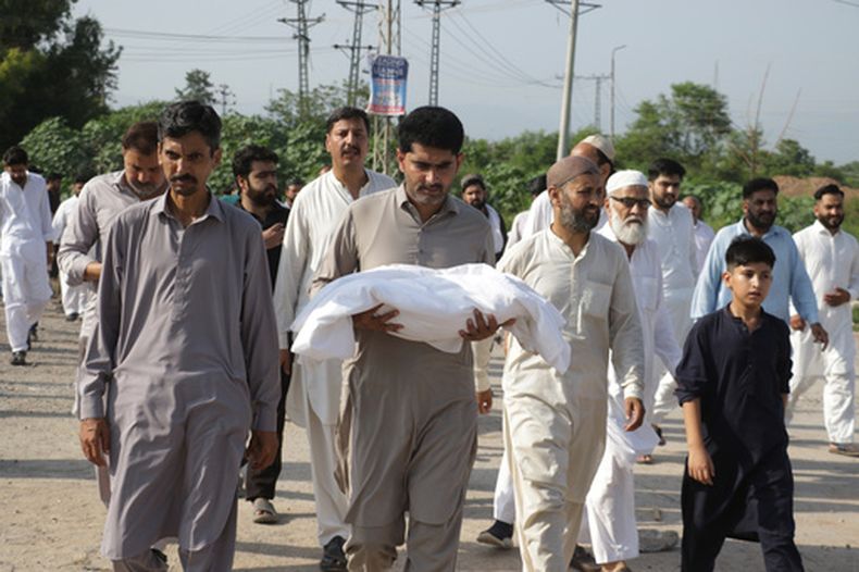 Un hombre lleva el cuerpo de un recién nacido en brazos para enterrarlo tras un incendio en un hospital en Islamabad, Pakistán, el 26 de agosto de 2026. (AP Foto/Ehsan Shahzad)