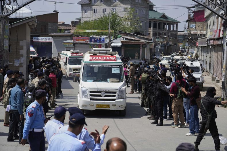 La policía hace guardia mientras ambulancias trasladan los cuerpos de turistas en Srinagar, en la Cachemira controlada por India, el 23 de abril de 2025. (AP Foto/Mukhtar Khan)