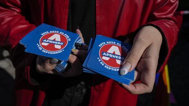 ARCHIVO - Miembros de organizaciones LGBTQ+ reparten calcomanías en apoyo a un nuevo borrador de la Constitución en Santiago, Chile, el 15 de agosto de 2022, que luego fue rechazado por los votantes en un plebiscito. Los partidos políticos presentarán un segundo proyecto de Constitución para que los electores decidan en un nuevo plebiscito el 17 de diciembre. (AP Foto/Esteban Félix, Archivo)