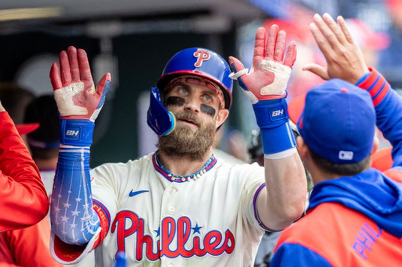Bryce Harper, de los Filis de Filadelfia, es felicitado en el dugout desués de batear un jonrón solitario en la quinta entrada del juego de béisbol de Grandes Ligas contra los Rays de Tampa Bay, el domingo 27 de septiembre de 2026, en Filadelfia. (AP Foto/Laurence Kesterson)