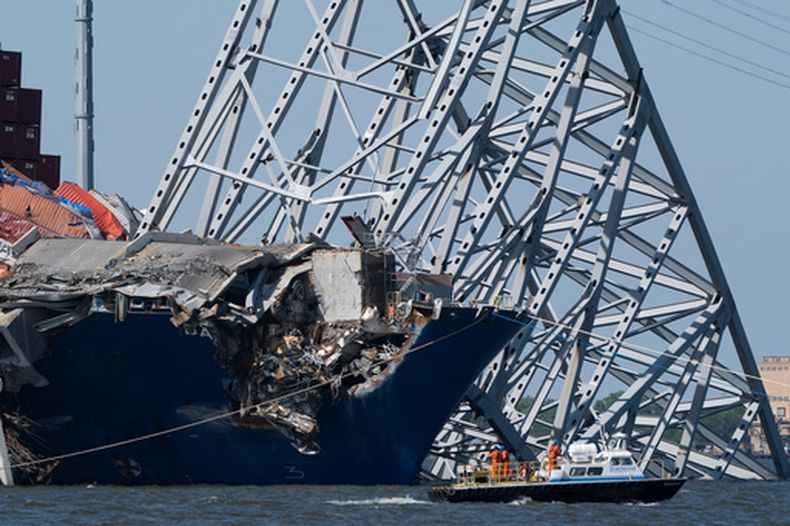 ARCHIVO – Un bote pasa frente al casco del buque contenedor Dali antes de la detonación de explosivos para derribar varias secciones del puente Francis Scott Key Bridge que se apoyan en el barco, el 13 de mayo de 2024, en Baltimore. (AP Foto/Mark Schiefelbein, Archivo)