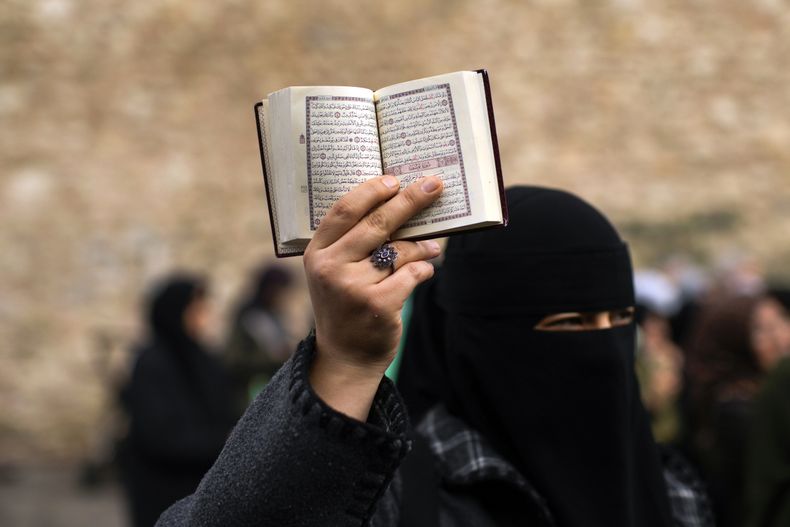 ARCHIVO - Una mujer sostiene un ejemplar del Corán durante una protesta afuera del consulado de Suecia en Estambul, Turquía, el 22 de enero de 2023. (AP Foto/Francisco Seco, Archivo)