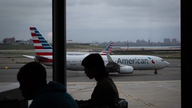 Gente esperando a vuelos mientras un avión de American Airlines circula por la pista en el aeropuerto LaGuardia (LGA) en el barrio de Queens, Nueva York, el domingo 9 de noviembre de 2025. (AP Foto/Adam Gray)