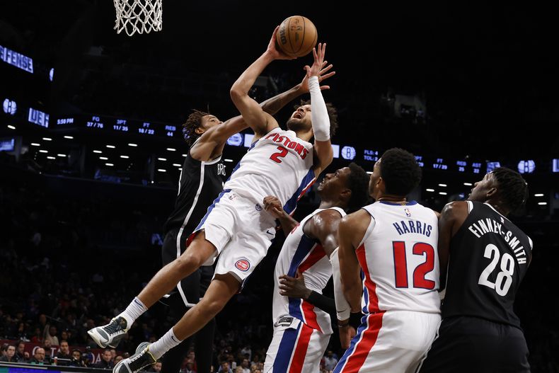 Cade Cunningham, de los Pistons de Detroit recibe una falta mientras lanza ante Nick Claxton (izquierda) de los Nets de Brookyln, durante el cuarto período del juego de baloncesto de la NBA, el domingo 3 de noviembre de 2024, en Nueva York. (AP Foto/Jason DeCrow)