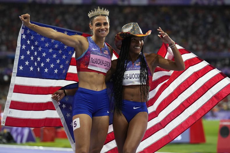 Las estadounidenses Tara Davis-Woodhall (derecha) y Sydney McLaughlin-Levrone posan para fotos durante los Juegos Olímpicos de París, el jueves 8 de agosto de 2024, en Saint-Denis, Francia. (AP Foto/Petr David Josek)