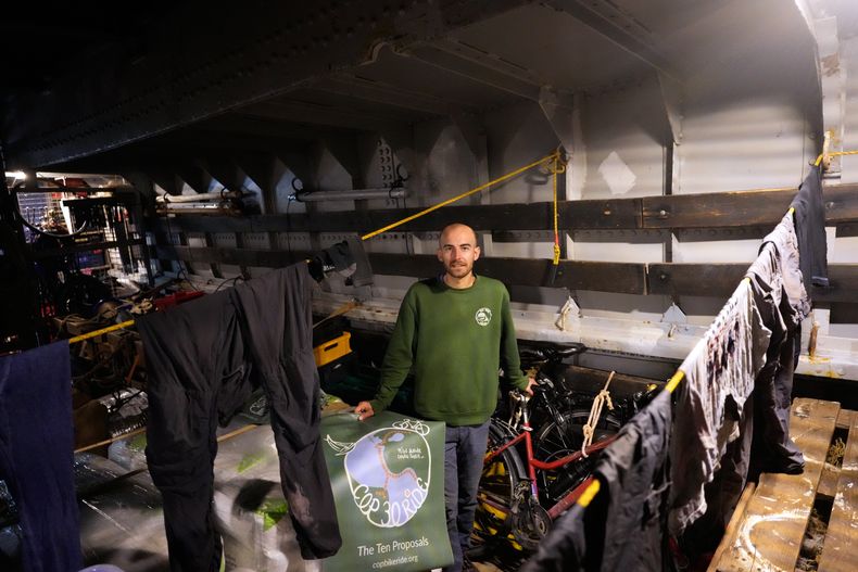 Antoine Polliand, de Francia, que viajó en bicicleta de Azerbaijan a Portugal con el Recorrido Ciclista COP30, posa con su bicicleta en la bodega de carga del barco Avontuur anclado en Cascais, en las afueras de Lisboa, el sábado 4 de octubre de 2025. Forma parte de un grupo que se dirige a Belém, Brasil, la ciudad amazónica que será sede de la cumbre climática COP30 de la ONU en noviembre. (AP Foto/Armando Franca)