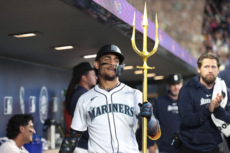 El dominicano de los Marineros de Seattle Julio Rodríguez celebra en el dugout tras conectar su jonrón de dos carreras frente a los Rangers de Texas el sábado 15 de junio del 2024. (AP Foto/Jason Redmond)