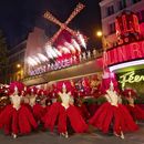 Bailarines actúan afuera del cabaret Moulin Rouge para celebrar la reactivación de las enormes aspas del molino, el jueves 10 de julio de 2025. (Moulin Rouge via AP)