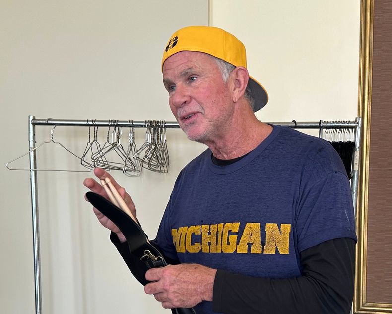 El baterista de los Red Hot Chili Peppers, Chad Smith, sostiene un par de baquetas en el Hill Auditorium del campus de la Universidad de Michigan el domingo 2 de noviembre de 2025, en Ann Arbor, Michigan. (Foto AP/Mike Householder)