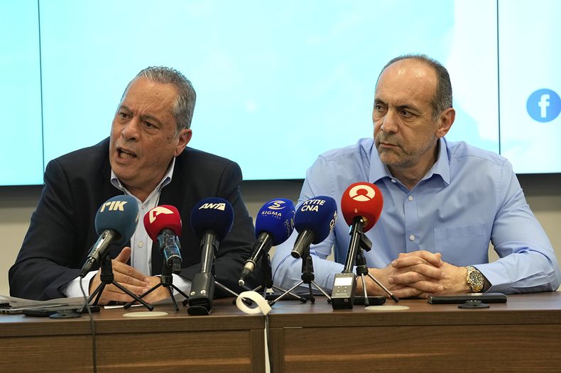 El ministro de Defensa de Chipre, Vasilis Palmas (izquierda), y el de Justicia y Orden Público, Marios Hartsiotis, hablan con reporteros en un centro de coordinación en Larnaca, Chipre, el 17 de marzo de 2025, tras el naufragio de un barco con migrantes en la costa. (AP Foto/Petros Karadjias)