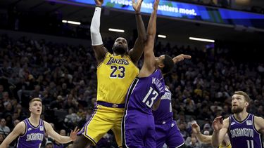 El alero de los Lakers de Los Ángeles LeBron James lanza el balón sobre el alero de los Kings de Sacramento Keegan Murray el jueves 19 de diciembre del 2024. (AP Foto/Jed Jacobsohn)
