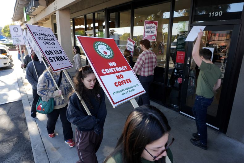 Trabajadores de Starbucks protestan frente a una de sus cafeterías, el viernes 20 de diciembre de 2024, en Burbank, California. (AP Foto/Damian Dovarganes)