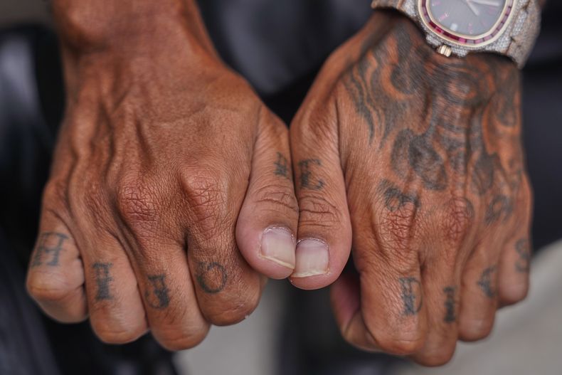 El reggaetonero puertorriqueño Zion muestra sus tatuajes que dicen hijo de Dios durante una entrevista en la Ciudad de México, el 25 de septiembre de 2025. (Foto AP/Jon Orbach)