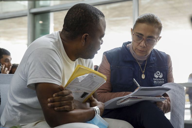 Una funcionaria entrevista a un migrante que fue deportado por Estados Unidos a su llegada en un avión fletado al aeropuerto de Bogotá, Colombia, el jueves 11 de mayo de 2023. La autoridad migratoria colombiana dijo que 209 colombianos fueron trasladados en un vuelo fletado desde la frontera entre Estados Unidos y México. (Foto AP/John Vizcaíno)