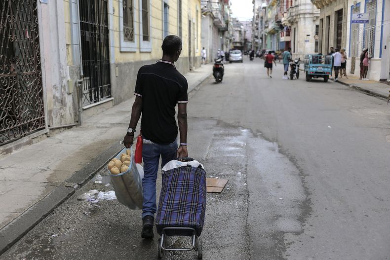Un hombre lleva un carro de la compra con una bolsa llena de pan, en La Habana, Cuba, el lunes 11 de marzo de 2024. Durante 60 años la libreta de abastecimiento fue el pilar de la alimentación en la isla. Pero las cosas han cambiado y en las últimas protestas la consigna de los manifestantes fue “corriente y comida” en alusión a los recurrentes apagones y al desabastecimiento de alimentos. (AP Foto/Ariel Ley)
