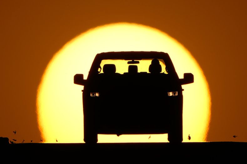 Un automóvil y un ocaso del sol en Lenexa, Kansas, el 26 de marzo del 2026. (AP foto/Charlie Riedel)