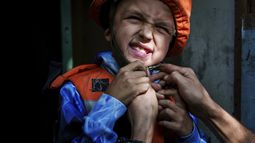 Un trabajador de rescate coloca un casco a Bohdan Scherbyna, de 9 años, mientras es evacuado con su madre Maryna Scherbyna, y su hermana de 14 años, Angelina Scherbyna, en Pokrovsk, en la región de Donbás, Ucrania, el martes 20 de agosto de 2024. (AP Foto/Evgeniy Maloletka)