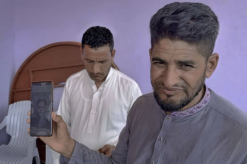 Raja Sakundar, derecha, muestra en su teléfono una foto de su sobrino, desaparecido tras un naufragio frente a la costa de Grecia, en la Cachemira paquistaní, 18 de junio de 2023. Las autoridades paquistaníes dijeron el miércoles 21 de junio de 2023 que han arrestado a siete presuntos miembros de una pandilla de traficantes de seres humanos luego del naufragio de un buque sobrecargado frente a la costa de Grecia que dejó más de 500 desaparecidos, entre ellos muchos paquistaníes. (AP Foto/Nasir Mehmood)