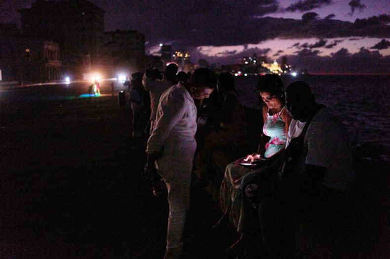 Gente pasa la noche en la oscuridad en el Malecón durante un apagón en La Habana, Cuba, el sábado 21 de marzo 2026. (AP Foto/Ramón Espinosa)