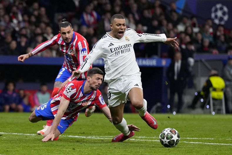 Clement Lenglet (centro) del Atlético de Madrid le comete una falta a Kylian Mbappé del Real Madrid en los octavos de final de la Liga de Campeones, el miércoles 12 de marzo de 2025. (AP Foto/Manu Fernández)