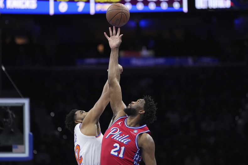 Joel Embiid de los 76ers de Filadelfia, derecha, y Karl-Anthony Towns de los Knicks de Nueva York luchan por el balón durante el primer tiempo en la NBA Cup, el martes 12 de noviembre de 2024, en Filadelfia. (AP Photo/Matt Slocum)