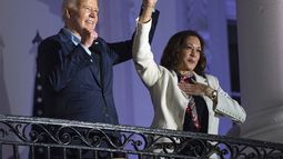 El presidente estadounidense Joe Biden alza la mano de la vicepresidenta Kamala Harris tras observar los fuegos artificiales lanzados por el Día de la Independencia desde el balcón de la Casa Blanca, el jueves 4 de julio de 2024, en Washington. (AP Foto/Evan Vucci)