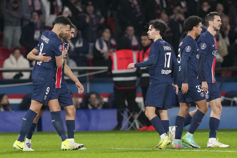 Gonçalo Ramos del PSG, a la izquierda, celebra con sus compañeros de equipo después de anotar el tercer gol de su equipo durante el partido de fútbol de la League One francesa entre el Paris Saint-Germain y el Lyon en el Parque de los Príncipes en París, el domingo 15 de diciembre de 2024. (AP Foto/Aurelien Morissard)