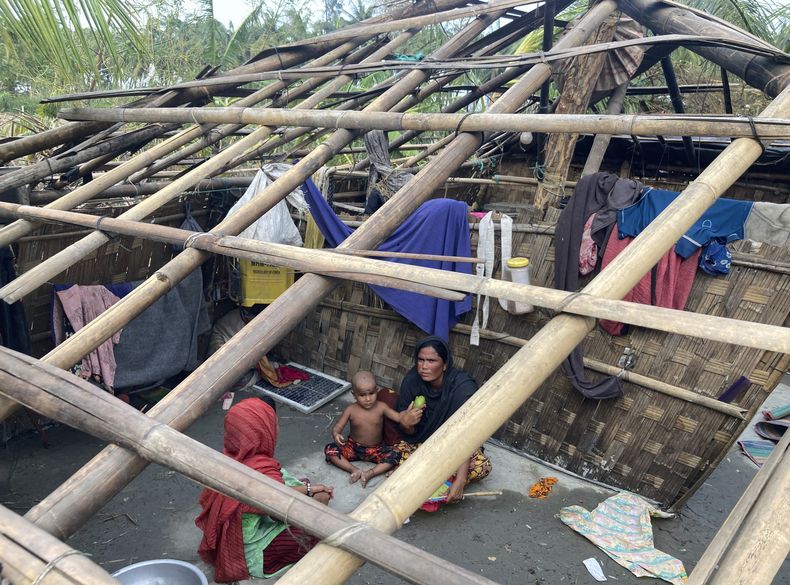 ARCHIVO - Una familia descansa dentro de su casa dañada tras el paso del ciclón Mocha en la isla de San Martín, Bangladesh, el lunes 15 de mayo de 2023. (AP Foto/Al-emrun Garjon, Archivo)