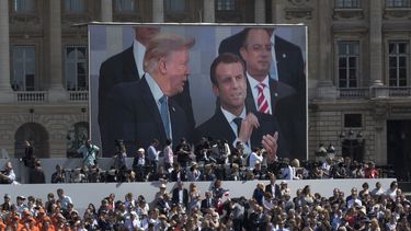 ARCHIVO - El presidente estadounidense Donald Trump --en la pantalla a la izquierda--, el mandatario francés Emmanuel Macron y el jefe de despacho de la Casa Blanca, Reince Priebus, --atrás a la derecha-- observan un desfile por el Día de la Bastilla sobre la avenida Campos Elíseos, el 14 de julio de 2017, en París. (AP Foto/Carolyn Kaster, archivo)
