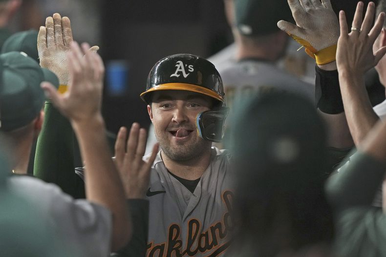 Shea Langeliers, de los Atléticos de Oakland, es felicitado en la cueva luego de conectar un jonrón de dos carreras ante los Rangers de Texas, el viernes 8 de septiembre de 2023 (AP Foto/LM Otero)