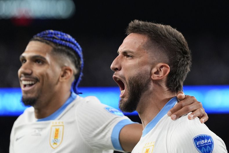 Rodrigo Bentancur (derecha) celebra con Ronald Araujo tras anotar el quinto gol de Uruguay en la victoria 5-0 ante Bolivia en el partido del Grupo C de la Copa América, el jueves 27 de junio de 2024, en East Rutherford, Nueva Jersey. (AP Foto/Julia Nikhinson)