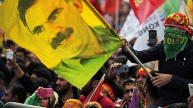 ARCHIVO – En esta foto de archivo del miércoles 21 de marzo de 2018, un joven sostiene una bandera con la imagen de Abdullah Ocalan, líder encarcelado del Partido de los Trabajadores de Kurdistán, o PKK, en Estambul, Turquía. (AP Foto/Lefteris Pitarakis, Archivo)