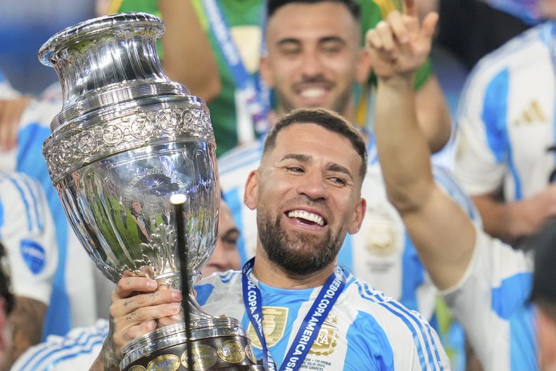 El defensor de Argentina Nicolás Otamendi celebra con el trofeo después de vencer a Colombia en la final de la Copa América en Miami, 15 de julio, 2024. (AP Foto/Julio Cortez)