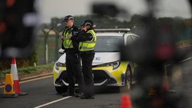 Policías protegen una carretera que lleva a la base RAF Fairford, tras un incidente en Fairford, Inglaterra, el lunes 28 de septiembre de 2026. (AP Foto/Alastair Grant)