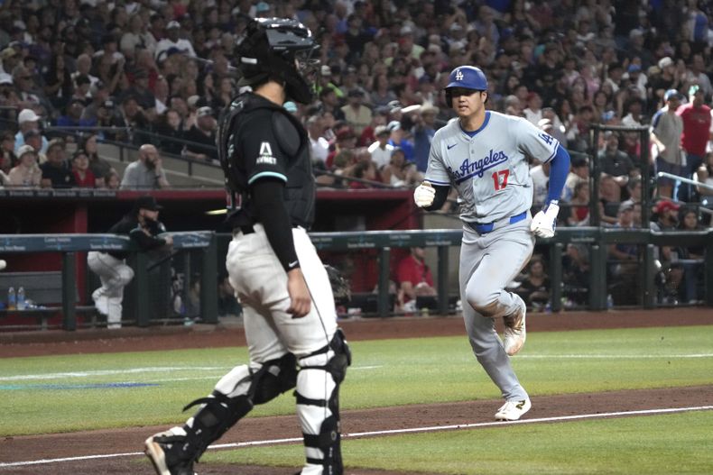 Shohei Ohtani, de los Dodgers de Los Ángeles corre para anotar ante los Diamondbacks de Arizona en un elevado de sacrificio de Freddie Freeman en el séptimo episodio del juego de béisbol, el lunes 2 de septiembre de 2024, en Phoenix. (AP Foto/Rick Scuteri)