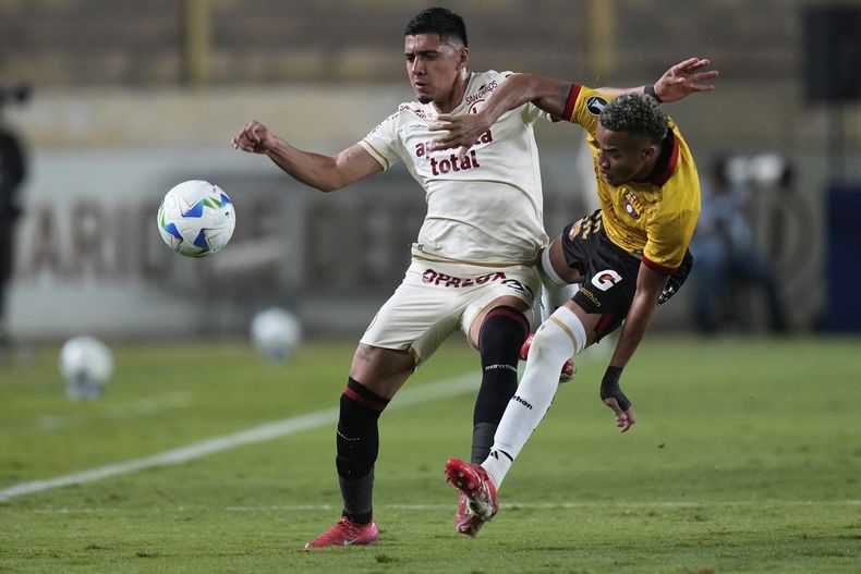 Byron Castillo del Barcelona de Ecuador pelea por el balón con César Inga del Universitario de Perú en el Grupo B de la Copa Libertadores el miércoles 14 de mayo del 2025. (AP Foto/Martin Mejia)