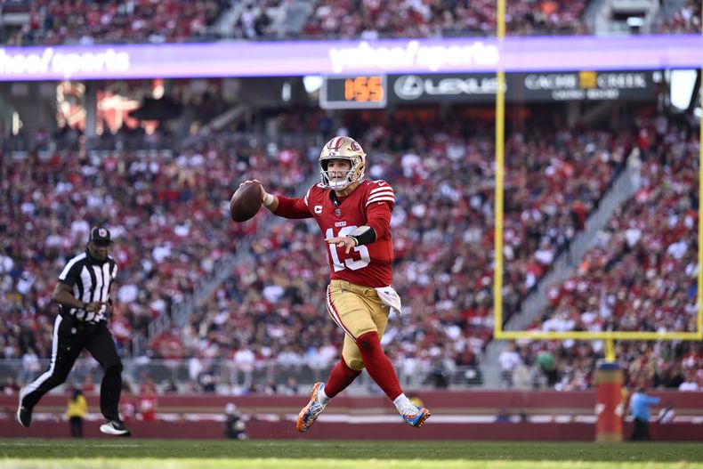 El quarterback de los 49ers de San Francisco, Brock Purdy (13), se lanza a pasar contra los Bears de Chicago durante la primera mitad de un partido de fútbol americano de la NFL en Santa Clara, California, el domingo 8 de diciembre de 2024. (AP Foto/Eakin Howard)