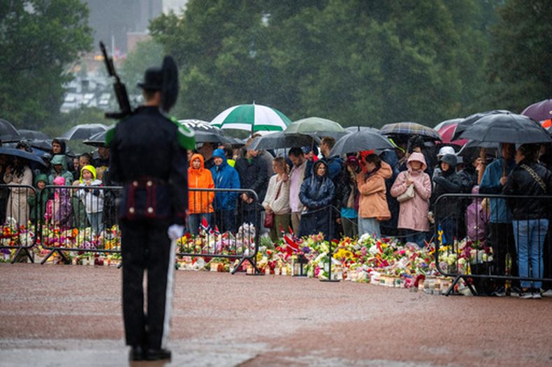 Dolientes esperan bajo la lluvia la llegada de los restos mortales del rey Harald V al Palacio Real en Oslo, Noruega, el 28 de agosto de 2026. (Heiko Junge/NTB via AP)