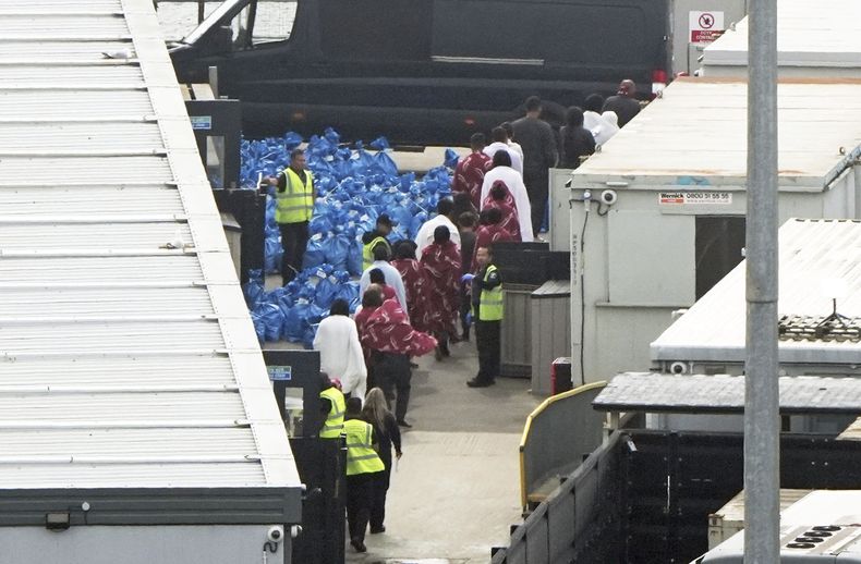 Un grupo de personas, al parecer migrantes, en la instalación de la fuerza de fronteras británica en Dover, Inglaterra, el 1 de junio del 2025, tras varios cruces de botes por el Canal de la Mancha. (Gareth Fuller/PA via AP)