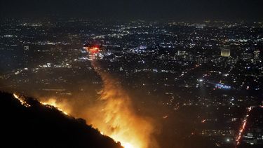 Agua es rociada desde un helicóptero sobre el incendio Sunset Fire en la sección Hollywood Hills de Los Ángeles, el miércoles 8 de enero de 2025. (Foto AP/Ethan Swope)