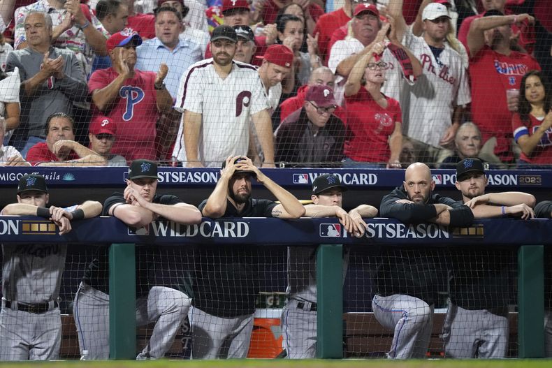 Jugadores de los Marlins de Miami observan desde el banquillo durante la séptima entrada del juego 1 por el comodín de la Liga Nacional ante los Filis de Filadelfia, martes 3 de octubre de 2023, en Filadelfia. (AP Foto/Matt Slocum)