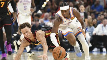 Shai Gilgeous-Alexander, derecha, del Thunder de Oklahoma City, intenta controlar un balón disputado con Dyson Daniels, izquierda, de los Hawks de Atlanta, durante la segunda mitad del juego de baloncesto de la NBA, el domingo 27 de octubre de 2024, en Oklahoma City. (AP Foto/Kyle Phillips)