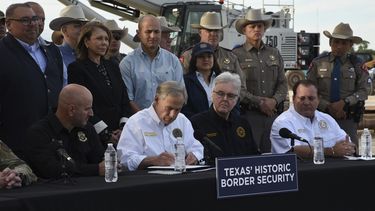 El gobernador de Texas, Greg Abbott, promulga tres iniciativas de ley el lunes 18 de diciembre de 2023, en un sitio ubicado frente al muro fronterizo, en Brownsville, Texas. (AP Foto/Valerie Gonzalez)