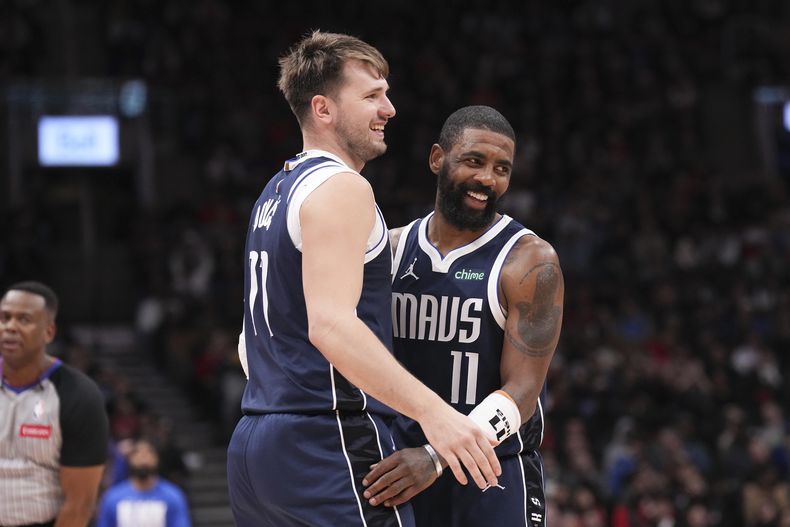 Luka Doncic y Kyrie Irving de los Dallas Mavericks reaccionan en la victoria de su equipo sobre los Raptors de Toronto, tras un partido de baloncesto de la NBA en Toronto, el miércoles 28 de febrero, de 2024. (Chris Young/The Canadian Press via AP)