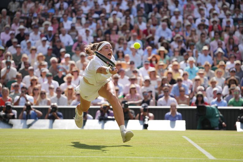 Karolina Muchova, de la República Checa, devuelve la pelota a Coco Gauff, de los Estados Unidos, quien celebra un punto en su contra en su partido de semifinales de individuales femeninos en el Campeonato de Tenis de Wimbledon, en Londres, el jueves 9 de julio de 2026. (Foto AP/Kin Cheung)