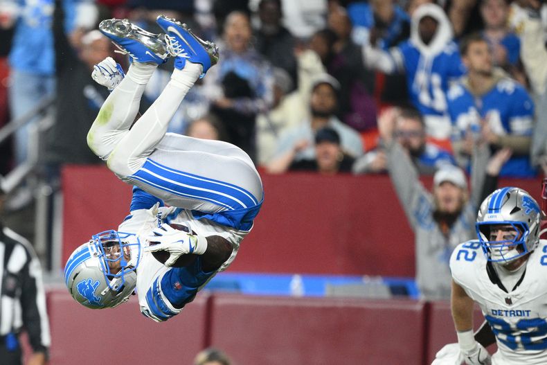 El wide receiver de los Lions de Detroit, Jameson Williams (1), anota mientras el tight end Ross Dwelley (82), compañero de equipo, observa durante la segunda mitad de un juego de fútbol americano de la NFL contra los Commanders de Washington, el domingo 9 de noviembre de 2025, en Landover, Md. (AP Photo/Nick Wass)