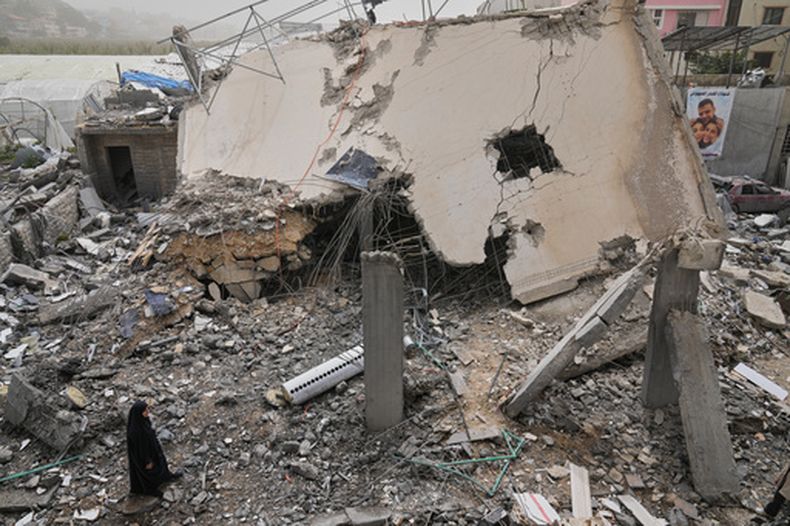 Una mujer revisa una casa destruida tras ser alcanzada por un ataque israelí en la localidad de Saksakiyeh, en el sur de Líbano, el 3 de abril de 2026. (AP Foto/Hussein Malla)