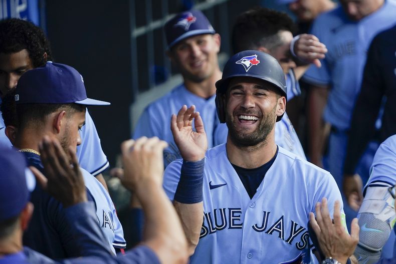 Kevin Kiermaier, de los Azulejos de Toronto, recibe la felicitación de sus compañeros en la banca tras anotar en un jonrón de dos carreras de Bo Bichette en el tercer inning del juego de la MLB que enfrentó a su equipo con los Dodgers de Los Ángeles, el 25 de julio de 2023, en Los Ángeles. (AP Foto/Ryan Sun)
