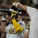 El jugador de los Padres de San Diego Fernando Tatis Jr. (23) pone un sombrero a su compañero Ha-Seong Kim después de que Kim pegara un jonrón de tres carreras en el quinto inning de su juego de béisbol contra los Rojos de Cincinnati, el lunes 1 de mayo de 2023 en San Diego. (AP Foto/Gregory Bull)